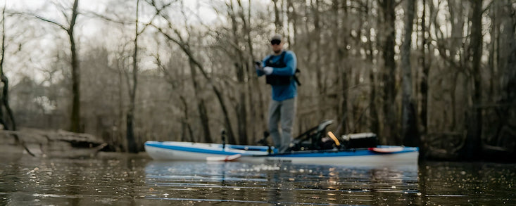 Man standing on fishing kayak